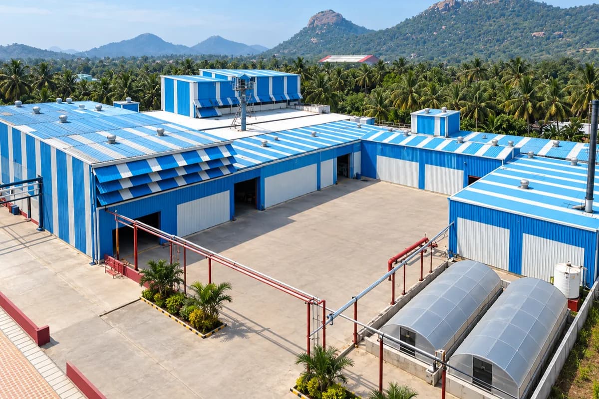 The TVP works at Omalur from the air: blue-roofed process buildings around a concrete yard, with the hills behind